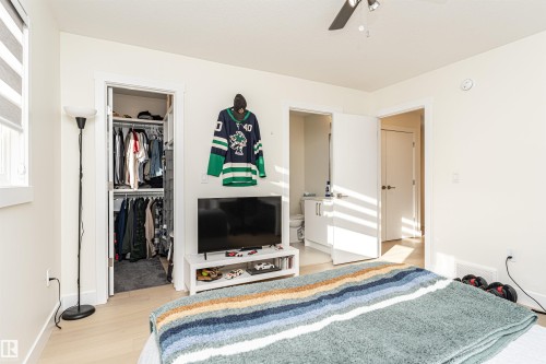 Bedroom with light wood-style floors, a walk in closet, and ceiling fan - 2 11569 University Avenue, Edmonton, AB - Indoor Photo Showing Bedroom