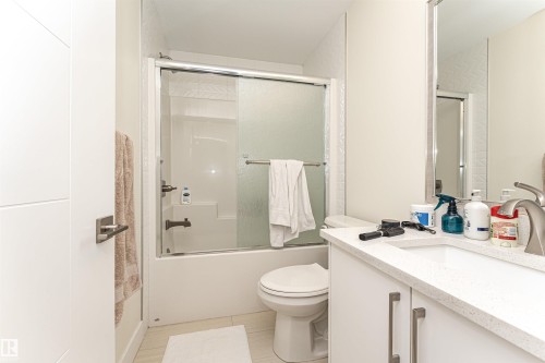 Bathroom with vanity and bath / shower combo with glass door - 2 11569 University Avenue, Edmonton, AB - Indoor Photo Showing Bathroom