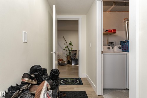 Laundry area with washing machine and clothes dryer and light wood-style flooring - 2 11569 University Avenue, Edmonton, AB - Indoor Photo Showing Laundry Room