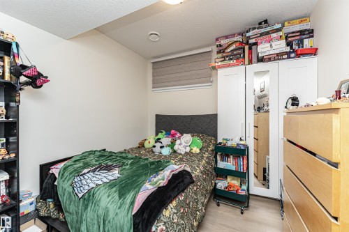 Bedroom featuring a textured ceiling and light wood-style flooring - 2 11569 University Avenue, Edmonton, AB - Indoor Photo Showing Bedroom
