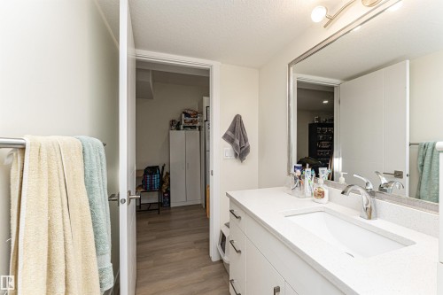 Bathroom featuring vanity, a textured ceiling, and light wood finished floors - 2 11569 University Avenue, Edmonton, AB - Indoor Photo Showing Bathroom