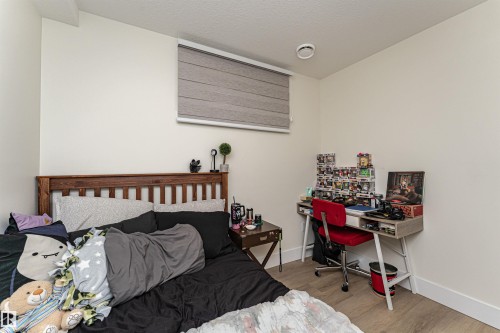 Bedroom with light wood-style floors, a desk, and a textured ceiling - 2 11569 University Avenue, Edmonton, AB - Indoor Photo Showing Bedroom