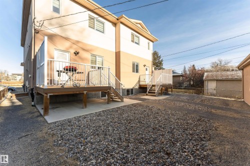 Rear view of house with stucco siding and a wooden deck - 2 11569 University Avenue, Edmonton, AB - Outdoor