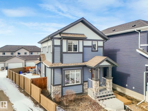 View of front of property with roof with shingles, stone siding, board and batten siding, and a residential view - 2428 Wonnacott Crest, Edmonton, AB - Outdoor