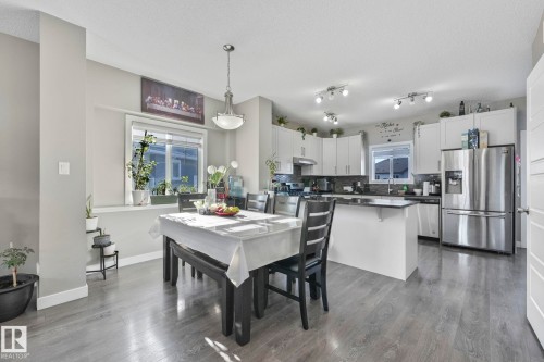 Dining space with a textured ceiling and dark wood-style flooring - 2428 Wonnacott Crest, Edmonton, AB - Indoor