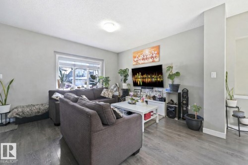 Living room featuring wood finished floors and a textured ceiling - 2428 Wonnacott Crest, Edmonton, AB - Indoor Photo Showing Living Room With Fireplace