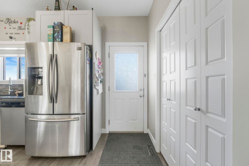 Kitchen featuring stainless steel appliances, dark wood finished floors, and white cabinets - 2428 Wonnacott Crest, Edmonton, AB - Indoor
