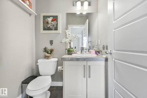 Half bathroom with vanity and dark wood-type flooring - 2428 Wonnacott Crest, Edmonton, AB - Indoor Photo Showing Bathroom