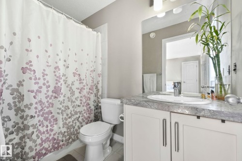 Full bath featuring vanity, a shower with curtain, and light tile patterned flooring - 2428 Wonnacott Crest, Edmonton, AB - Indoor Photo Showing Bathroom