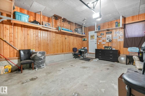 Garage featuring wood walls and a garage door opener - 2428 Wonnacott Crest, Edmonton, AB - Indoor Photo Showing Garage