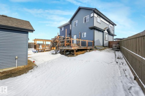 Snow covered house featuring a deck and a fenced backyard - 2428 Wonnacott Crest, Edmonton, AB - Outdoor With Deck Patio Veranda With Exterior