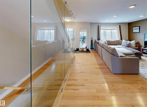 Living room featuring light wood finished floors, plenty of natural light, and recessed lighting - 8 9535 217 Street, Edmonton, AB - Indoor