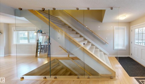 Stairs featuring wood-type flooring and a textured ceiling - 8 9535 217 Street, Edmonton, AB - Indoor Photo Showing Other Room