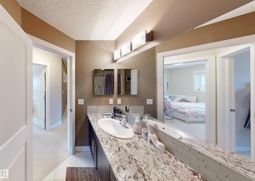 Ensuite bathroom featuring vanity, a textured ceiling, and light tile patterned flooring - 8 9535 217 Street, Edmonton, AB - Indoor Photo Showing Bathroom