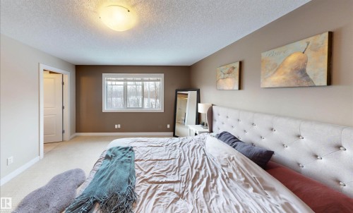 Bedroom with light colored carpet and a textured ceiling - 8 9535 217 Street, Edmonton, AB - Indoor Photo Showing Bedroom