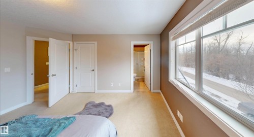 Bedroom featuring light colored carpet, a closet, and connected bathroom - 8 9535 217 Street, Edmonton, AB - Indoor