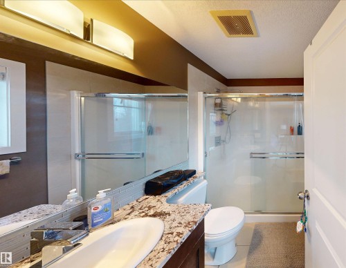 Bathroom featuring vanity, a shower stall, and a textured ceiling - 8 9535 217 Street, Edmonton, AB - Indoor Photo Showing Bathroom