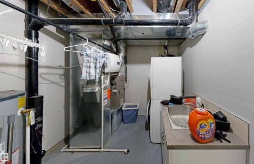 Utilities featuring water heater and heating unit - 8 9535 217 Street, Edmonton, AB - Indoor Photo Showing Basement