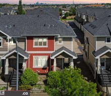 Townhome exterior featuring red vertical siding, gray horizontal siding, and dark shingle roofing - 