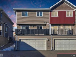 View of front of house featuring a balcony, an attached garage, and asphalt driveway - 