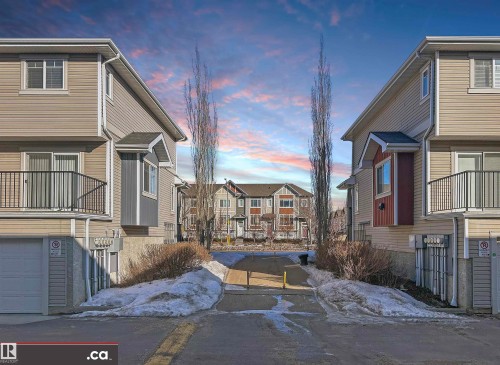 Patio terrace at dusk with a balcony and a residential view - 8 9535 217 Street, Edmonton, AB - Outdoor With Balcony With Facade