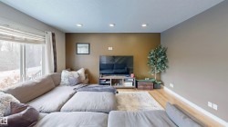 Living room with light wood-type flooring, recessed lighting, and a textured ceiling - 