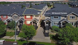 Red-sided multi-story residence featuring a dark shingle roof, white window trim, and a covered entry with dark stairs - 