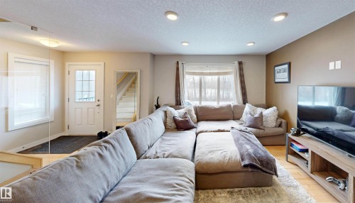 Living area featuring a textured ceiling, wood finished floors, and recessed lighting - 8 9535 217 Street, Edmonton, AB - Indoor Photo Showing Living Room