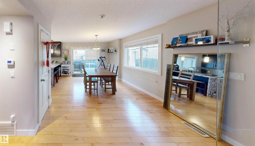 Dining room featuring light wood-type flooring and a textured ceiling - 8 9535 217 Street, Edmonton, AB - Indoor Photo Showing Dining Room