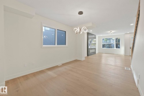 Unfurnished dining area with a chandelier, light wood-style floors, and recessed lighting - 10965 129 Street, Edmonton, AB - Indoor Photo Showing Other Room