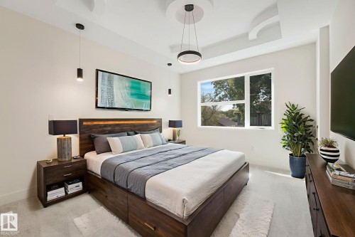Primary bedroom with a raised ceiling and light colored carpet - 10965 129 Street, Edmonton, AB - Indoor Photo Showing Bedroom