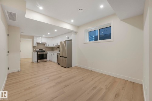 Rec room with white cabinetry, light countertops, appliances with stainless steel finishes, light wood finished floors, and recessed lighting - 10965 129 Street, Edmonton, AB - Indoor Photo Showing Kitchen