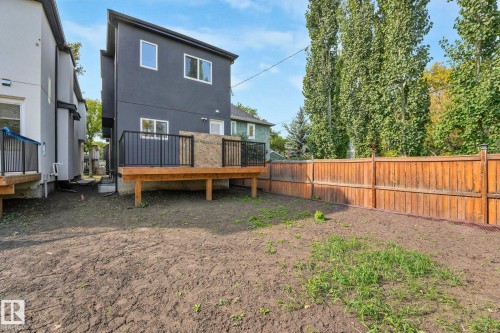 Rear view of house featuring a wooden deck and stucco siding - 10965 129 Street, Edmonton, AB - Outdoor With Deck Patio Veranda