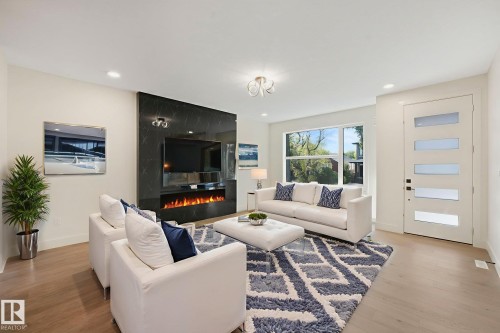Living room featuring light wood-style floors, a high end fireplace, and recessed lighting - 10965 129 Street, Edmonton, AB - Indoor Photo Showing Living Room