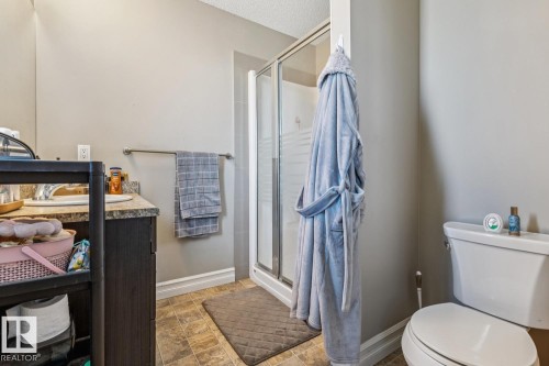 Bathroom with vanity, a stall shower, stone finish flooring, and a textured ceiling - 5409 3 Avenue, Edmonton, AB - Indoor Photo Showing Bathroom