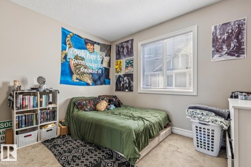 Carpeted bedroom with a textured ceiling and baseboards - 5409 3 Avenue, Edmonton, AB - Indoor Photo Showing Bedroom