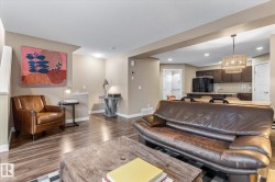 Living room with wood finished floors, a chandelier, and recessed lighting - 