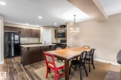 Dining area featuring dark wood-style floors and a chandelier - 