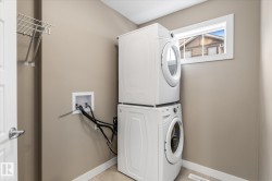 Laundry area featuring stacked washer / dryer and baseboards - 