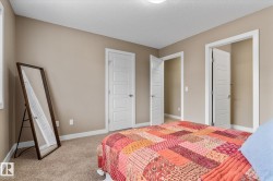 Bedroom featuring a closet, light carpet, and a textured ceiling - 