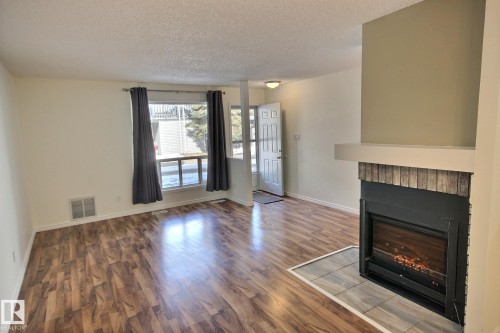 11 1503 Mill Woods Road E, Edmonton, AB - Indoor Photo Showing Other Room With Fireplace