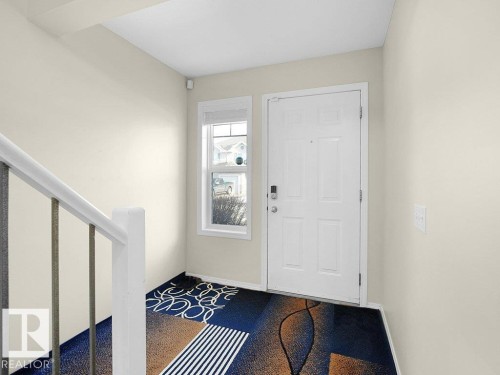 Entryway featuring dark colored carpet and stairs - 196 230 Edwards Drive, Edmonton, AB - Indoor Photo Showing Other Room