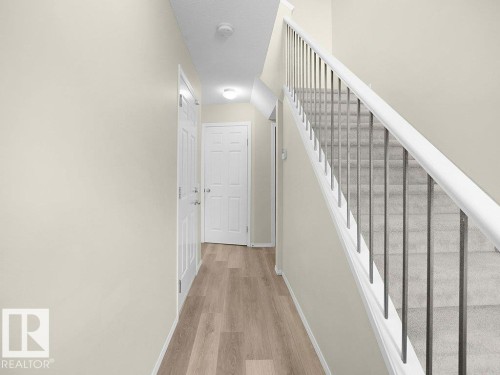 Stairway with baseboards and wood finished floors - 196 230 Edwards Drive, Edmonton, AB - Indoor Photo Showing Other Room