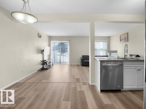 Kitchen featuring stainless steel dishwasher, light wood-style floors, and white cabinets - 196 230 Edwards Drive, Edmonton, AB - Indoor