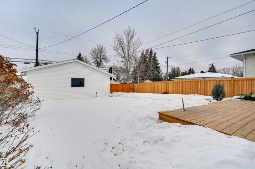 Yard layered in snow with a fenced backyard and a deck - 13932 118 Avenue, Edmonton, AB - Outdoor