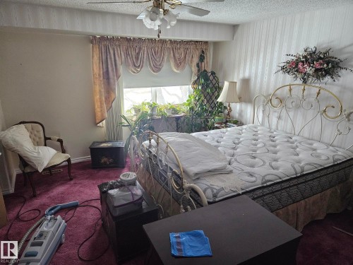 This room features a window with decorative valance and drapes, a ceiling fan with light fixture, and plush carpeting - 5404 146 Avenue Nw, Edmonton, AB - Indoor Photo Showing Bedroom