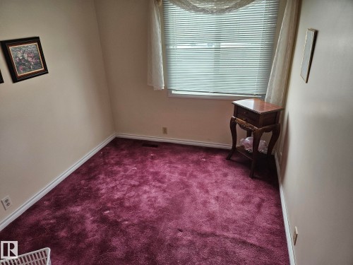 This room features neutral-toned walls, a window with blinds and curtains, and a maroon carpet - 5404 146 Avenue Nw, Edmonton, AB - Indoor Photo Showing Other Room
