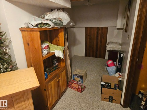 This room features a neutral carpet, white walls, and a wood-paneled accent wall - 5404 146 Avenue Nw, Edmonton, AB - Indoor