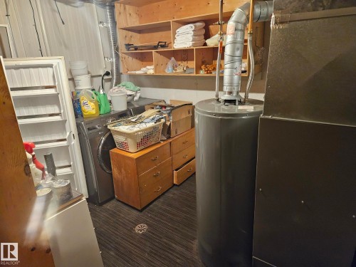 Utility area featuring a water heater, furnace, and a washer - 5404 146 Avenue Nw, Edmonton, AB - Indoor