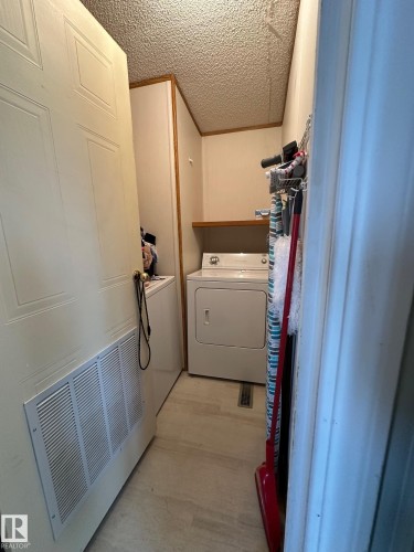 Dedicated laundry area featuring a white washing machine, white dryer, and light-colored flooring - 67 4204 47 Street, Wetaskiwin, AB - Indoor Photo Showing Laundry Room
